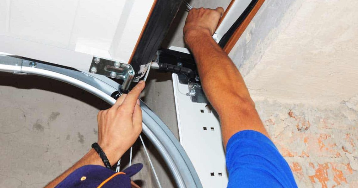 man repairing overhead garage door